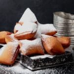 close up of sourdough beignets with powdered sugar