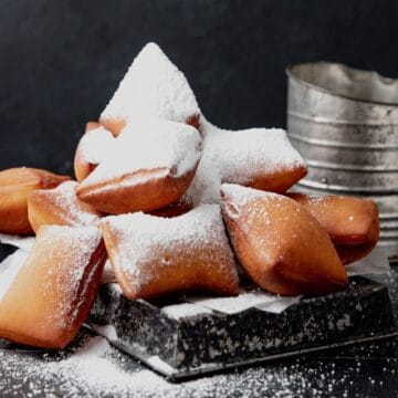 close up of sourdough beignets with powdered sugar