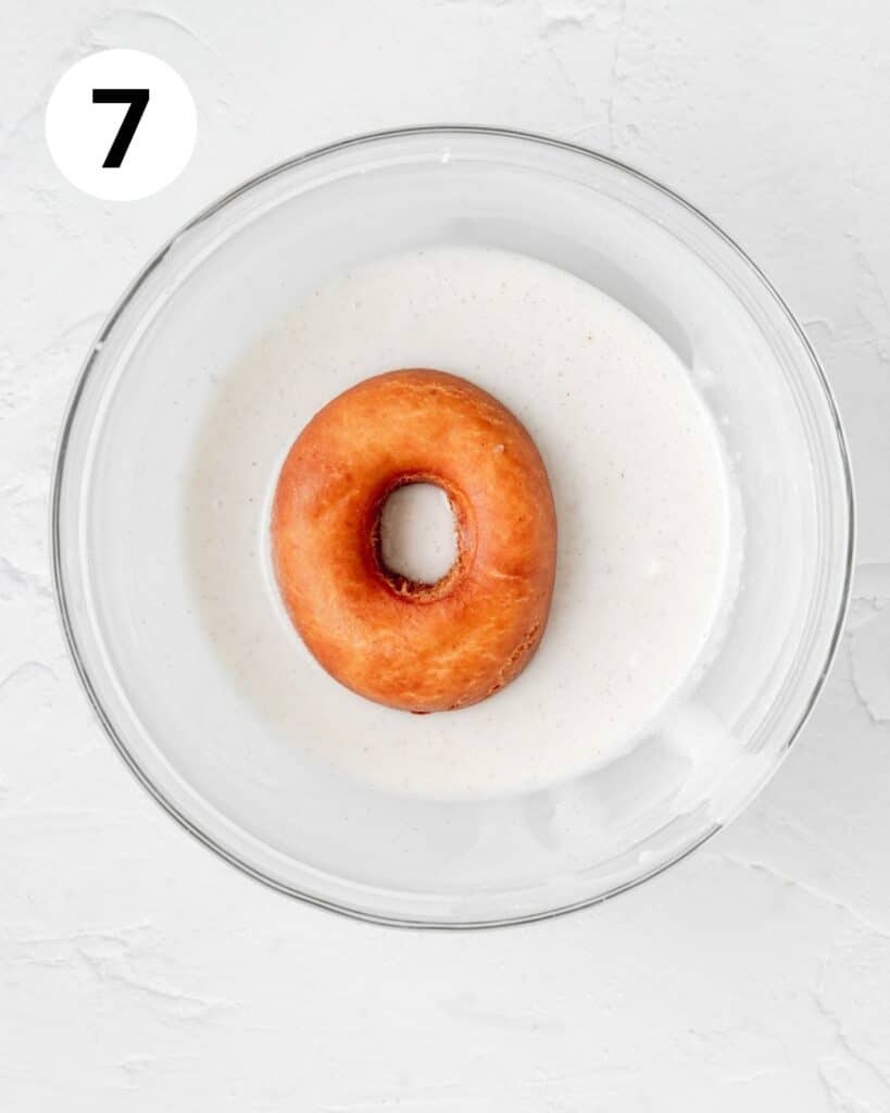 dipping donut in vanilla bean glaze