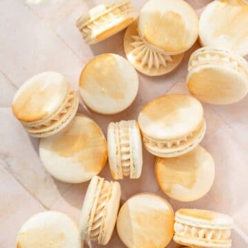 close up of champagne macarons with gold paint