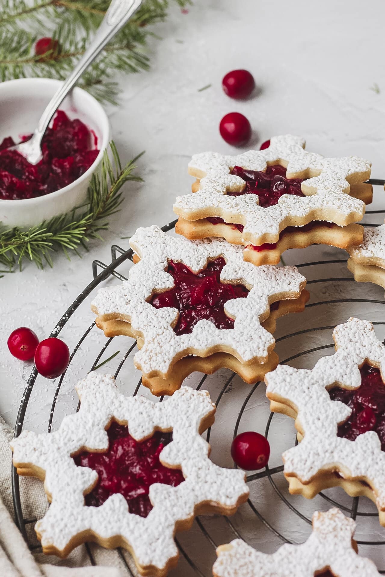 cranberry linzer cookies shaped like snowflakes.