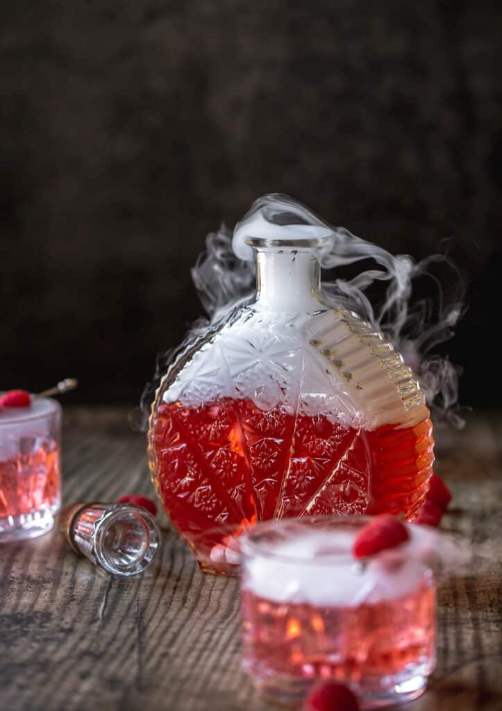 A glass cup on a table, with Ice and Chambord