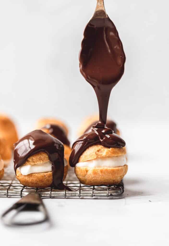 cream puffs with chocolate being drizzled