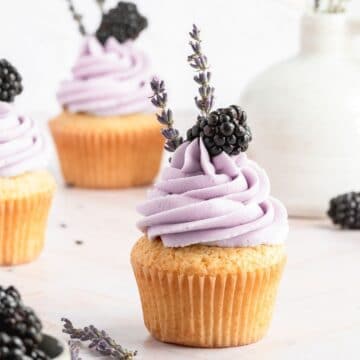 close up of blackberry lavender cupcakes with blackberry on top.