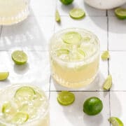 close up shot of key lime margaritas with slices of key limes