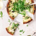 pesto pizza with roasted veggies and slice missing