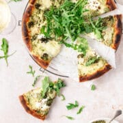 pesto pizza with roasted veggies and slice missing