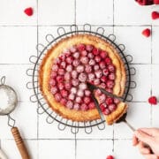 close up shot of raspberry almond frangipane tart with fresh raspberries on top