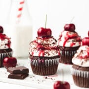 close up photo of black forest cupcakes with fresh cherries