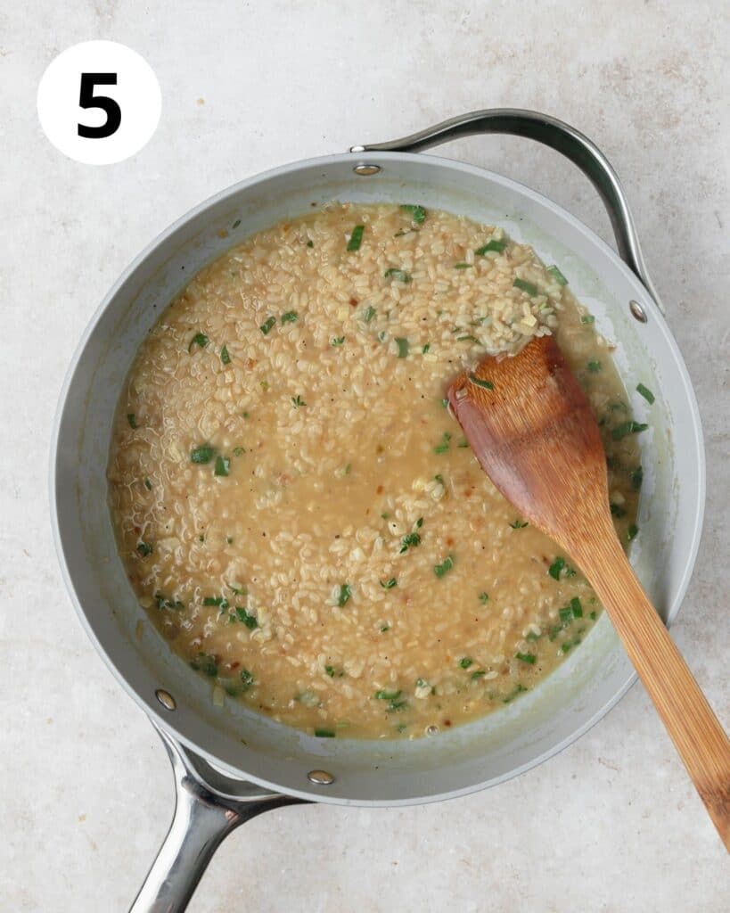 adding stock to risotto pan