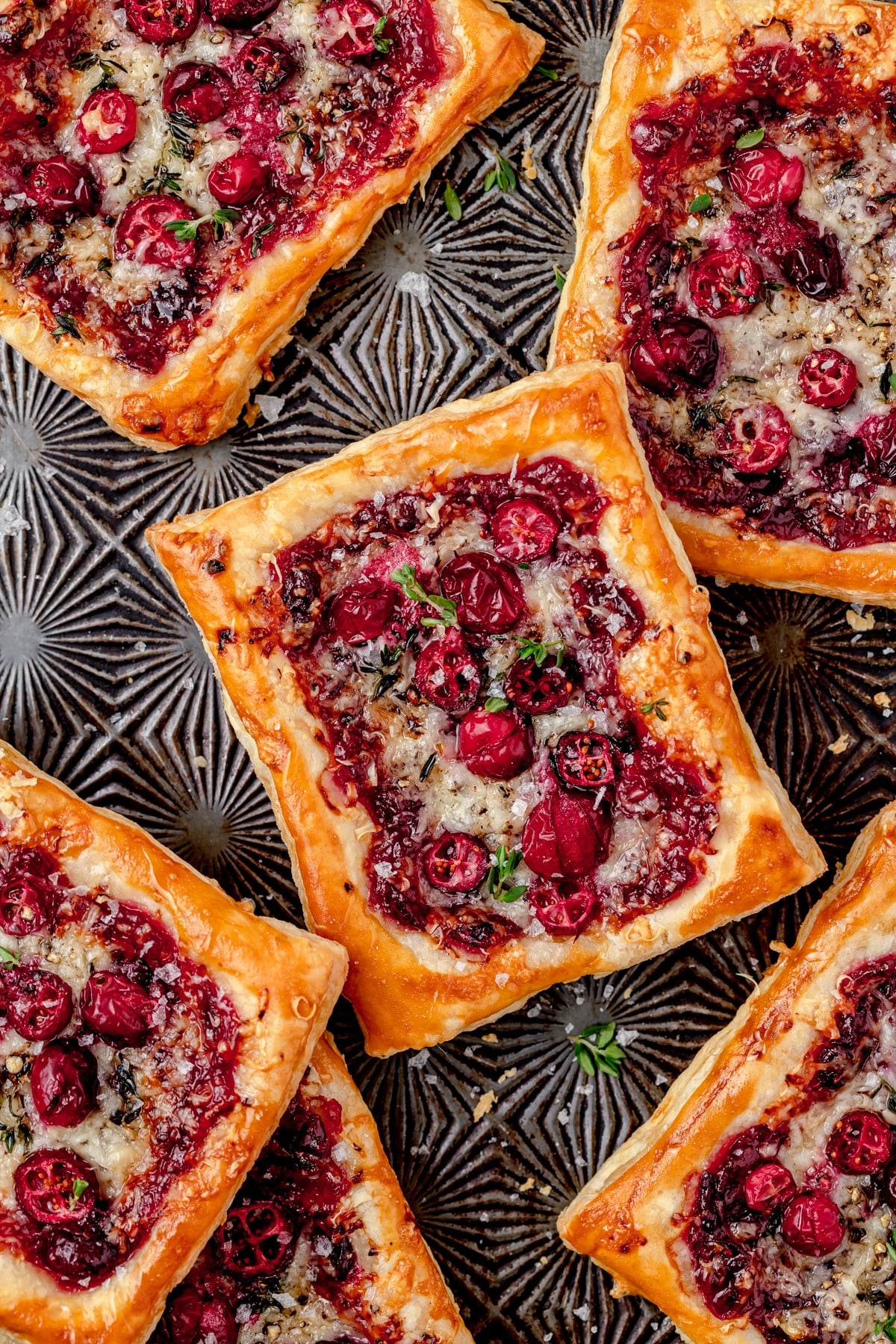 cranberry puff pastry tarts with gruyere on baking sheet