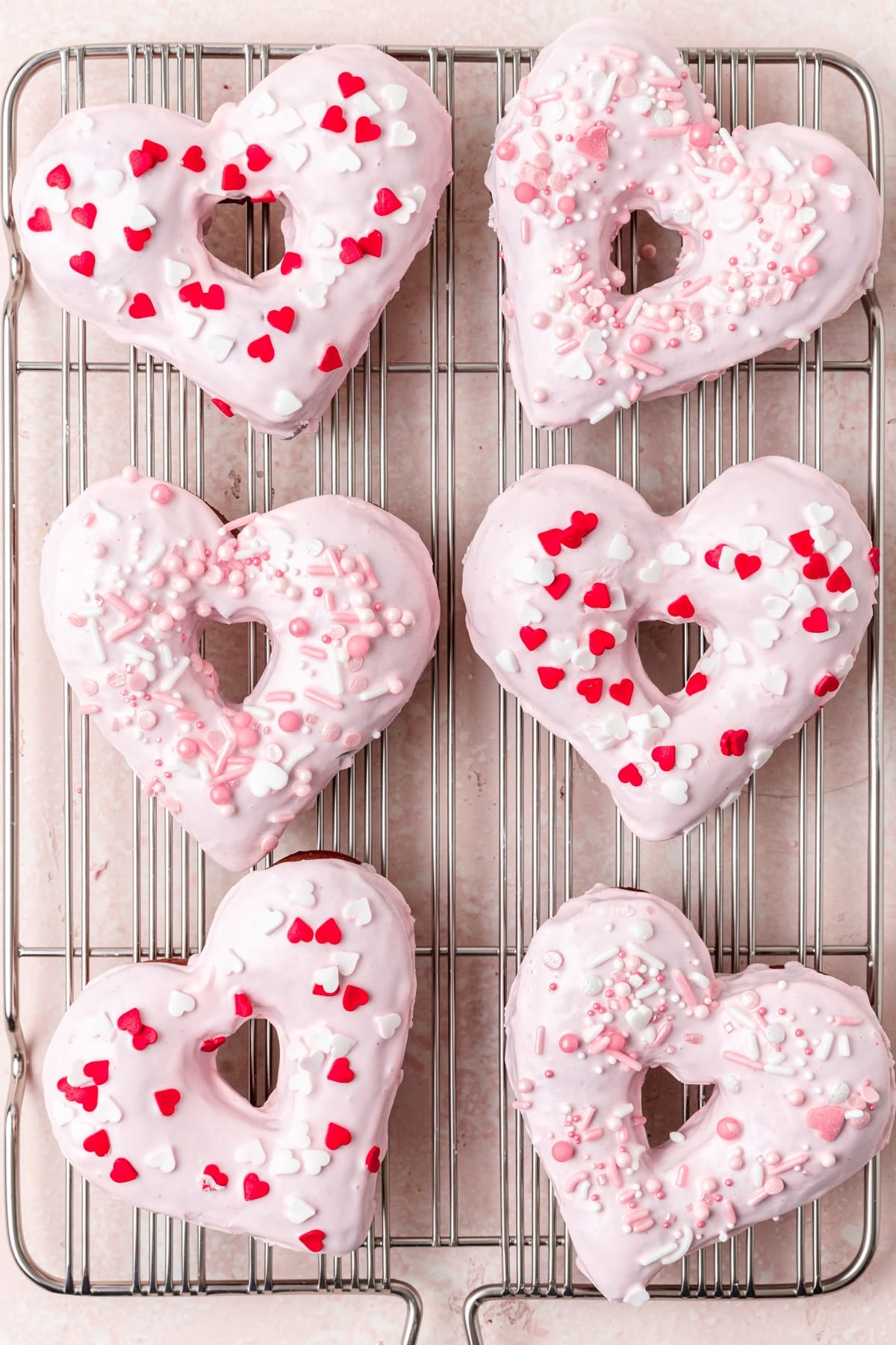 heart shaped donuts with pink glaze and sprinkles. 
