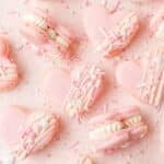 close up of heart shaped macarons with white chocolate ganache.