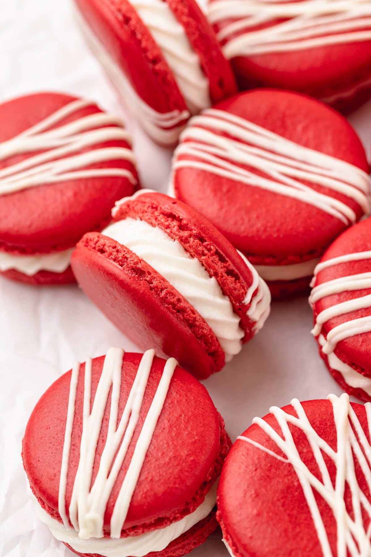 red velvet macarons with cream cheese frosting and white chocolate drizzle