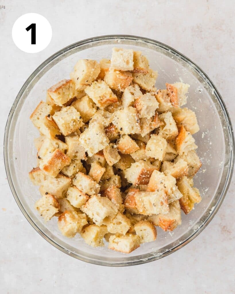 tossing bread with butter and spices.