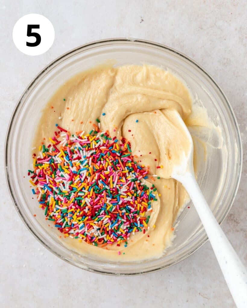 adding rainbow sprinkles to cake batter.