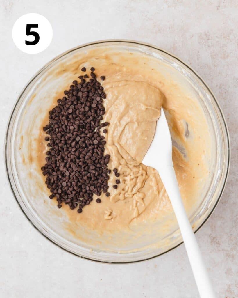 adding mini chocolate chips to banana muffin batter.