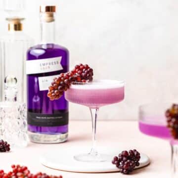 close up of empress gin french 75 with champagne grapes.