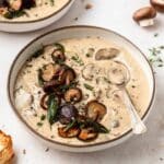 close up of bowl of homemade cream of mushroom soup with crispy mushrooms on top.