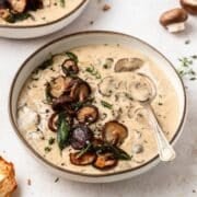 close up of bowl of homemade cream of mushroom soup with crispy mushrooms on top.
