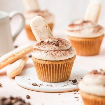 close up of tiramisu cupcakes with lady fingers on top.