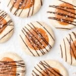 close up of caramel thumbprint cookies with chocolate drizzle.