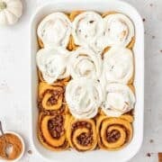 close up of pumpkin spice cinnamon rolls with maple and pecans.