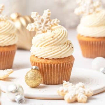 close up of bourbon eggnog cupcakes topped with snowflake cookies.