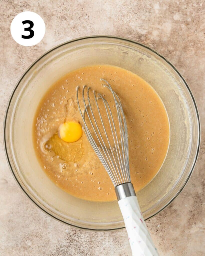 adding 4th egg to brownie batter.