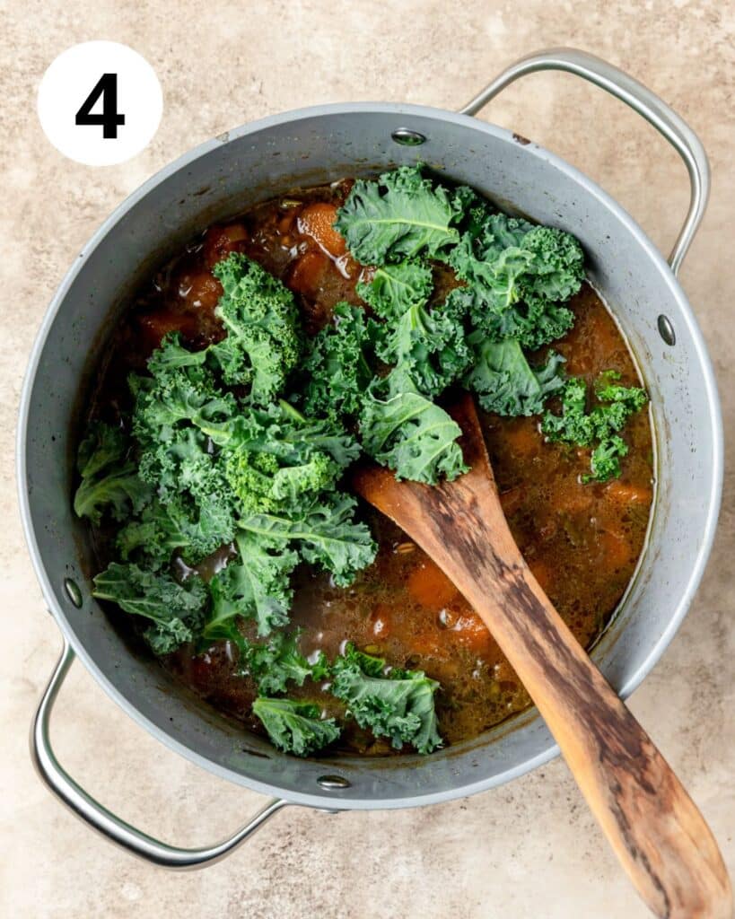 adding fresh kale to soup.