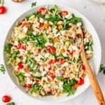 close up of bowl of orzo white bean salad with arugula.