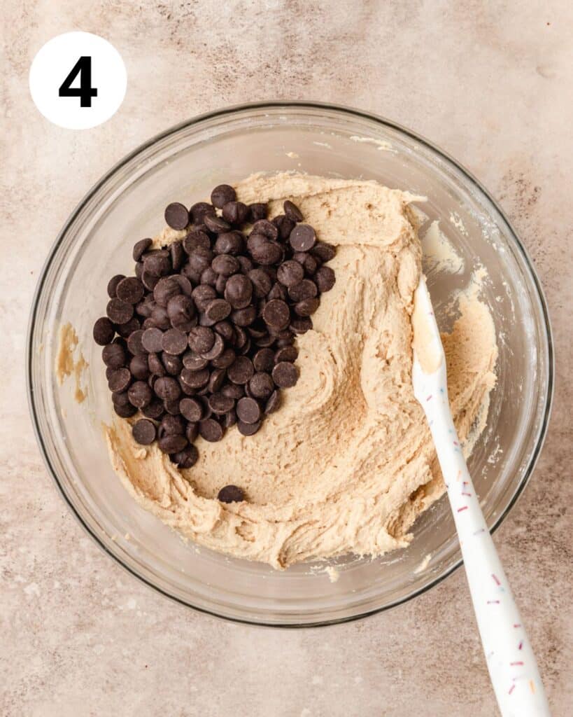 adding chocolate chips to blondie dough.