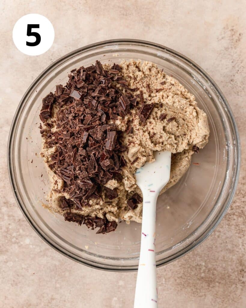 adding chocolate chunks to cookie dough.