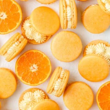 close up of orange creamsicle macarons.