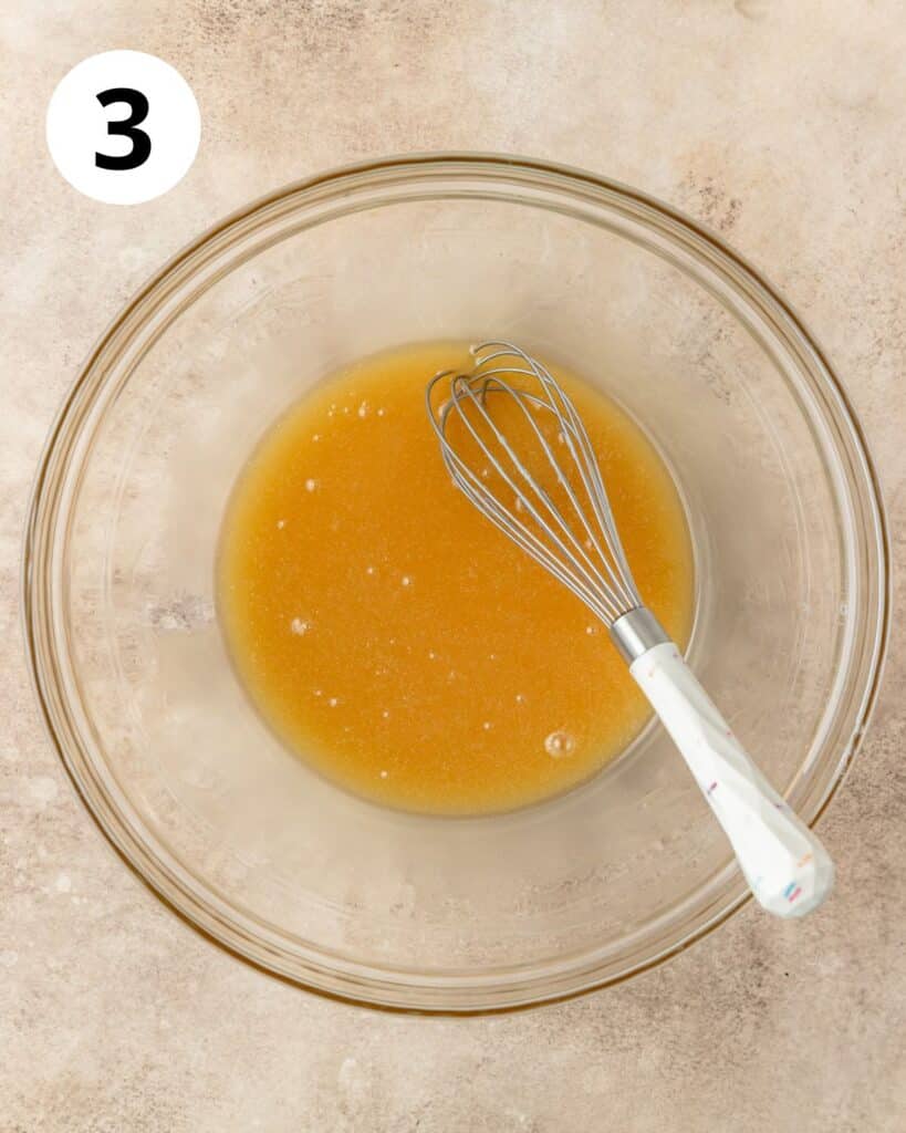 whisking melted butter and honey together in bowl.