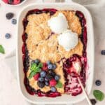 close up of mixed berry cobbler topped with vanilla ice cream.