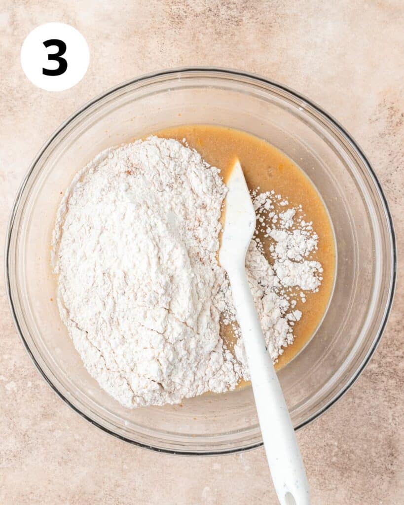 adding dry ingredients to donut batter.