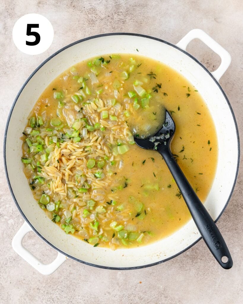 adding broth to cook orzo.