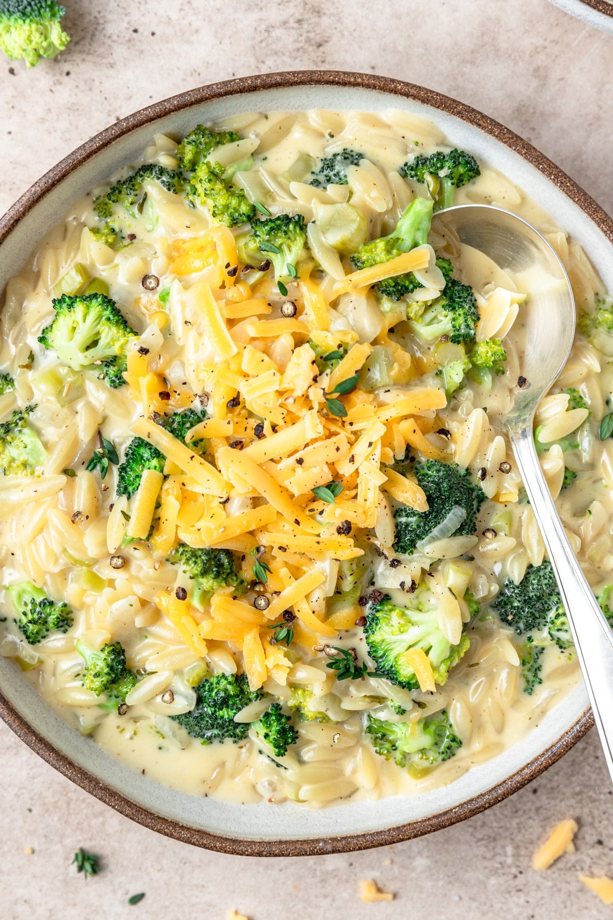 broccoli cheddar orzo pasta topped with cheese.