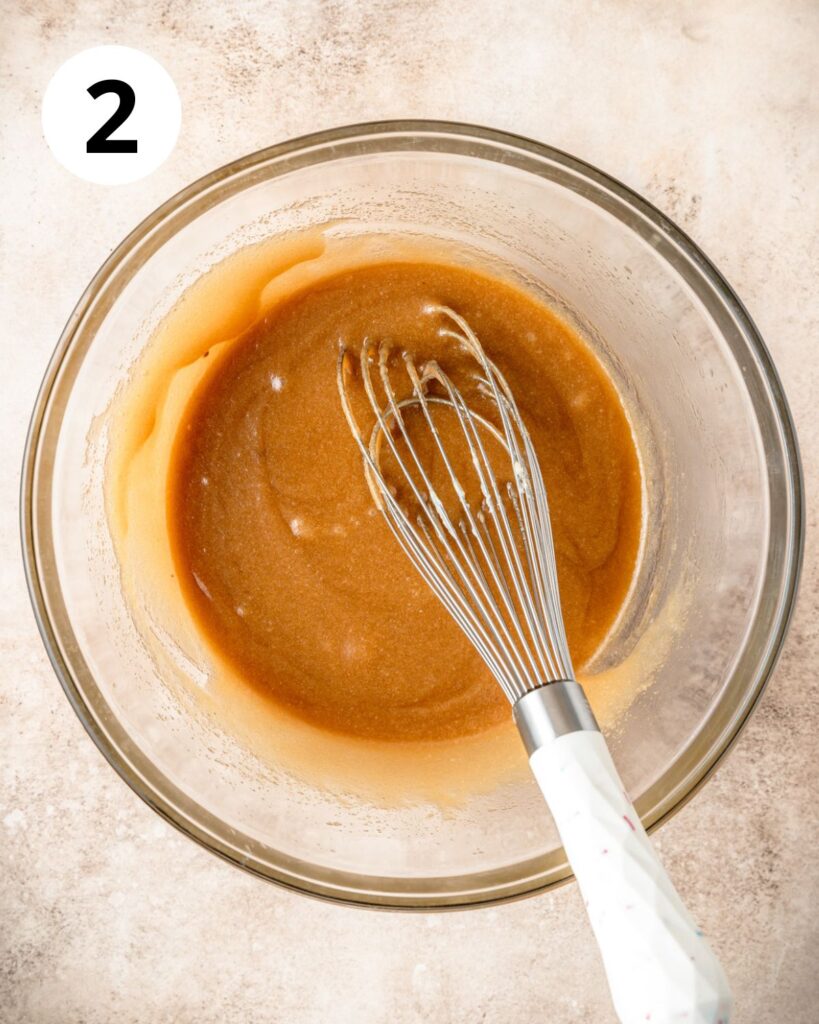 whisking together melted butter and sugars.