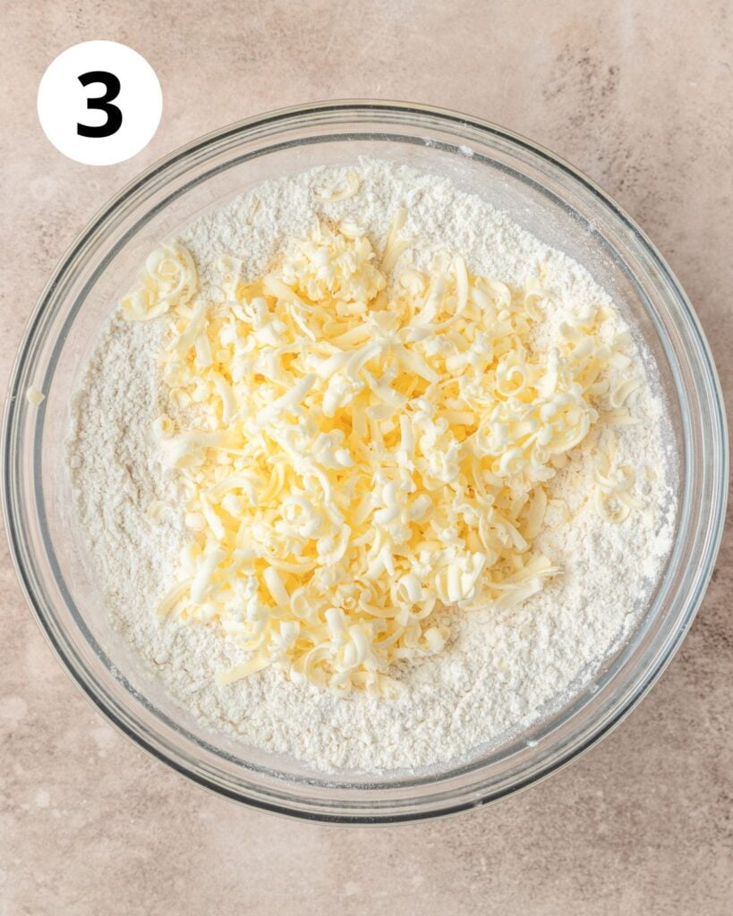 adding frozen grated butter to flour.