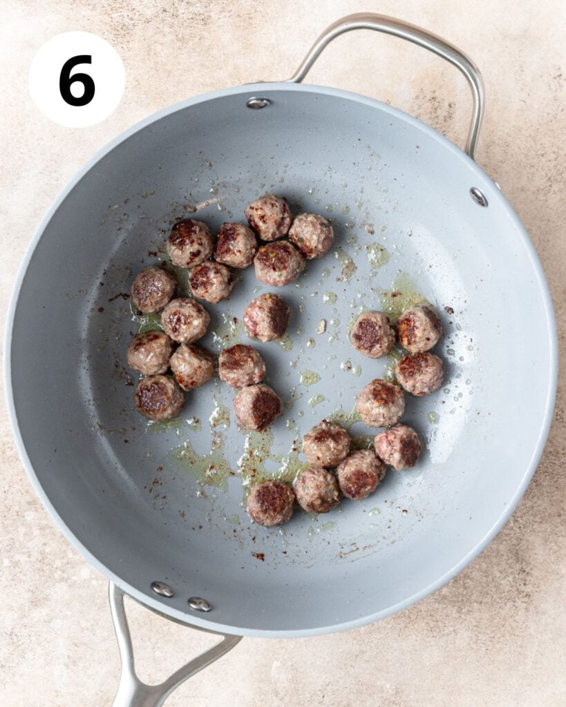 browned mini meatballs in pan.