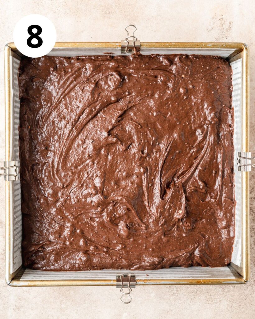 spreading brownie batter in square pan.