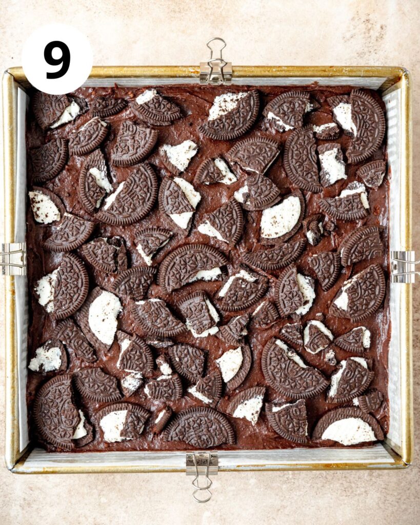 topping brownie batter with broken oreo cookies.