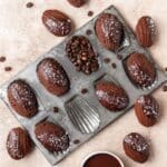 close up of dark chocolate espresso madeleines with flaky sea salt.