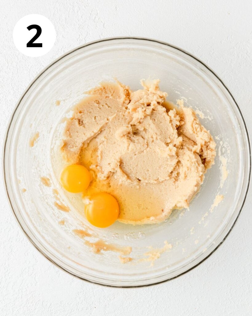 adding eggs to cookie dough.