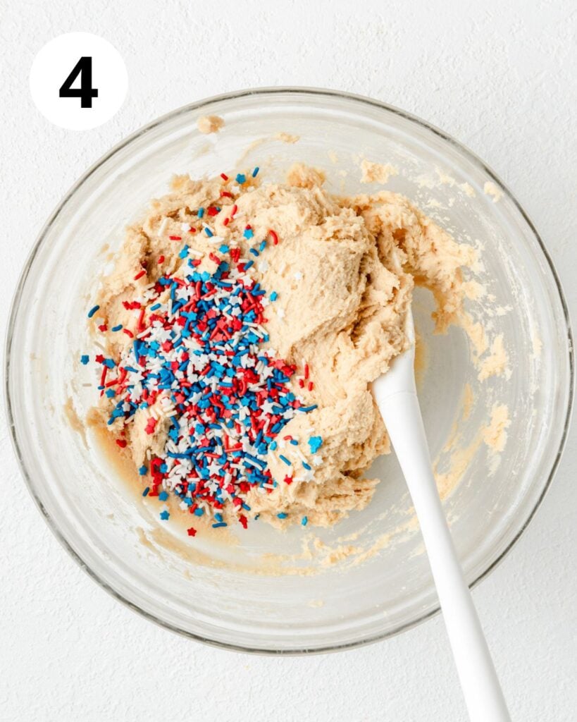 adding red white and blue sprinkles to cookie dough.
