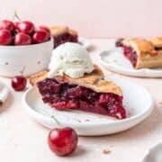 slice of homemade fresh cherry pie with scoop of vanilla ice cream.