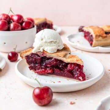 slice of homemade fresh cherry pie with scoop of vanilla ice cream.
