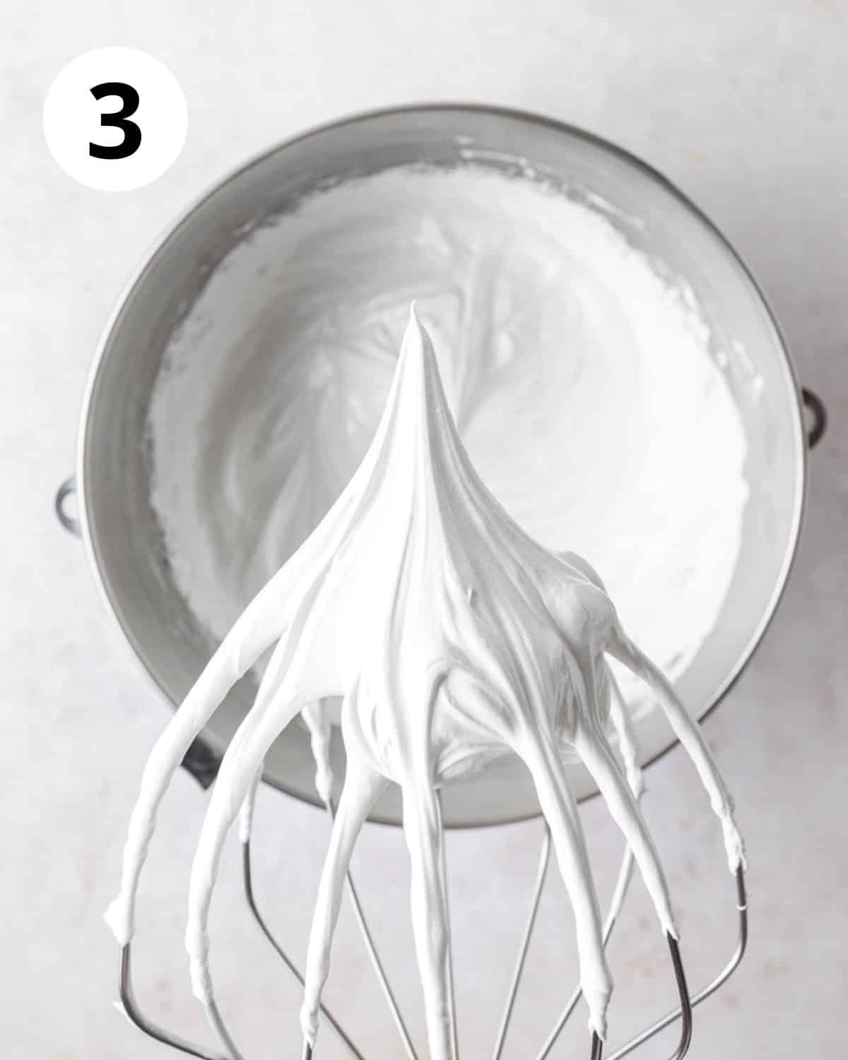 swiss meringue being whipped to stiff peaks.